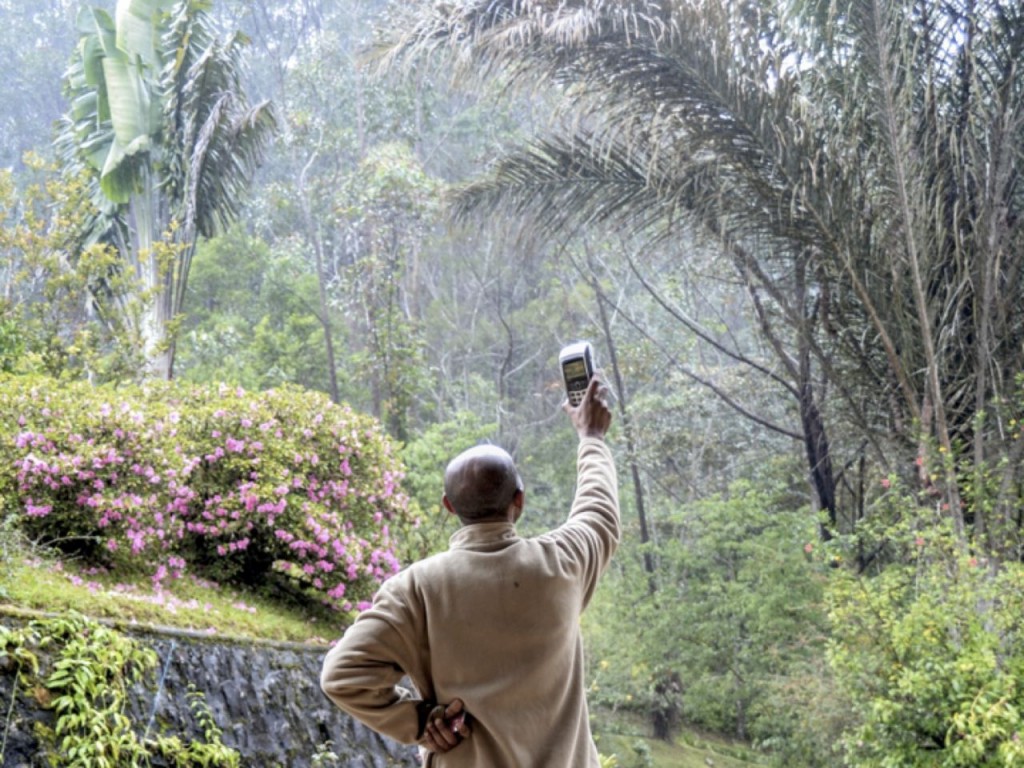 Merchant using a credit-card reader attempting to get a stronger signal to complete the transaction in Anosibe, Madagascar. Image credit, Steven Sinofsky