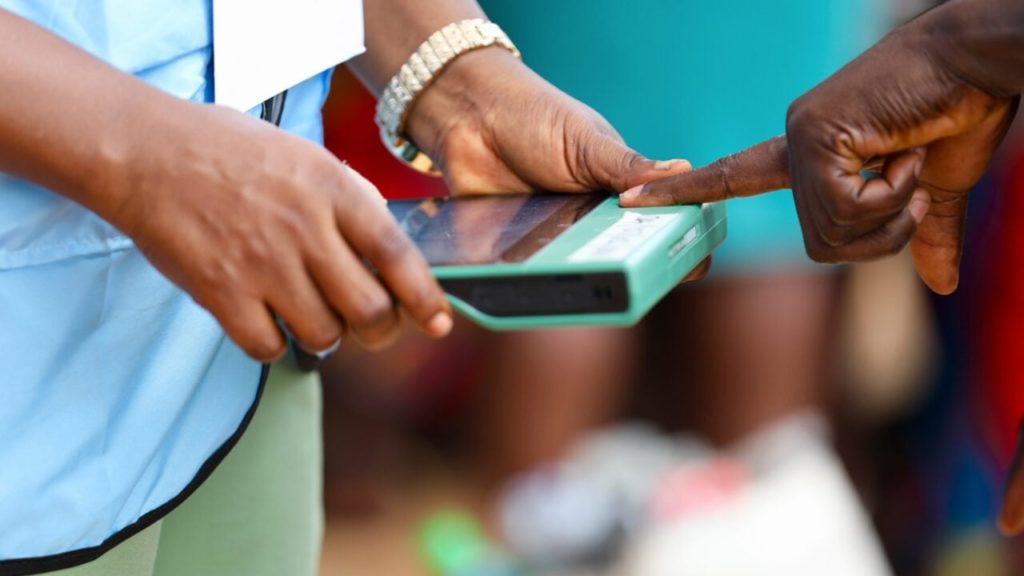 INEC officer verifying a permanent voter's card with a BVAS| Image source: Daily Trust