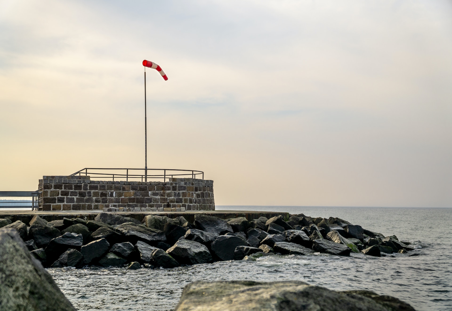 Beautiful photo of a windsock fluttering on a rock beside the sea at Rostock, Deutschland