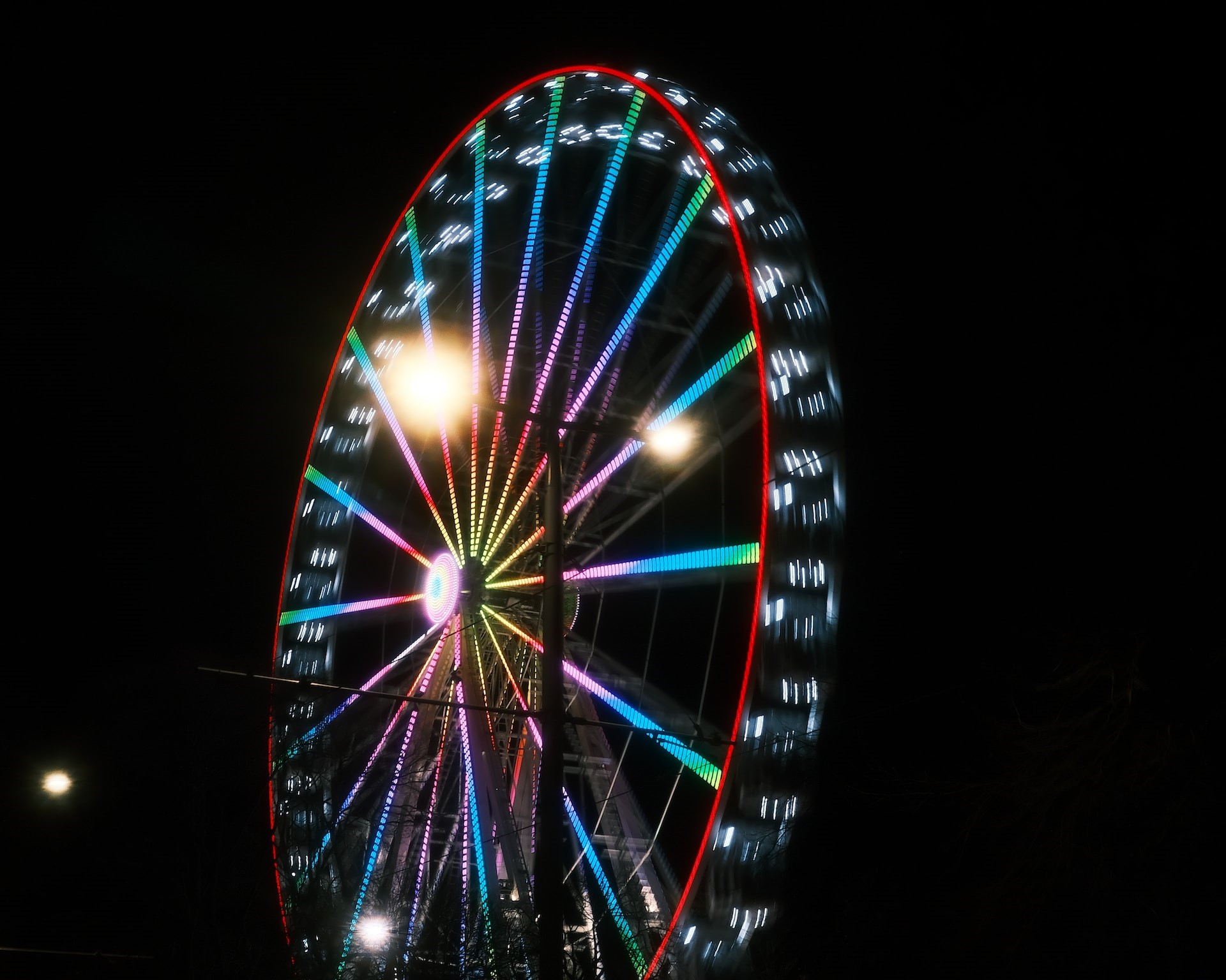 A night photo of a spinning Ferris wheel. Courtesy: Sasha Cures via Unsplash
